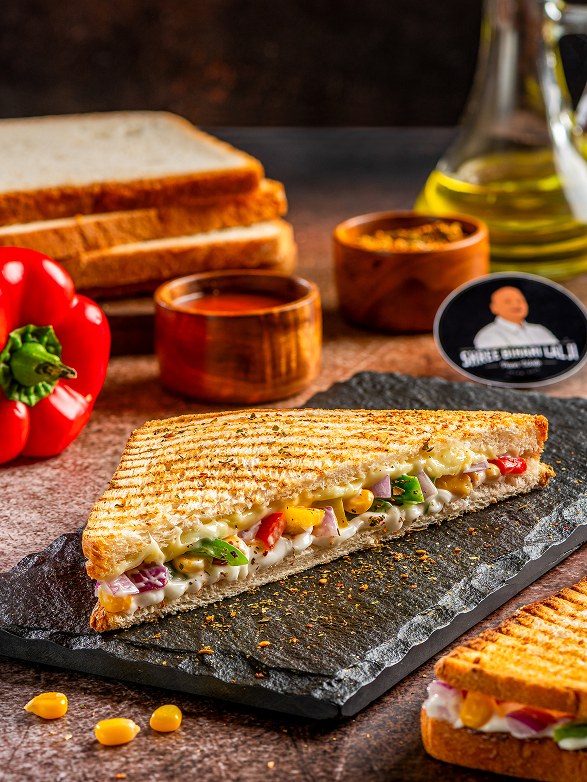 Grilled corn and vegetable sandwich on a slate board