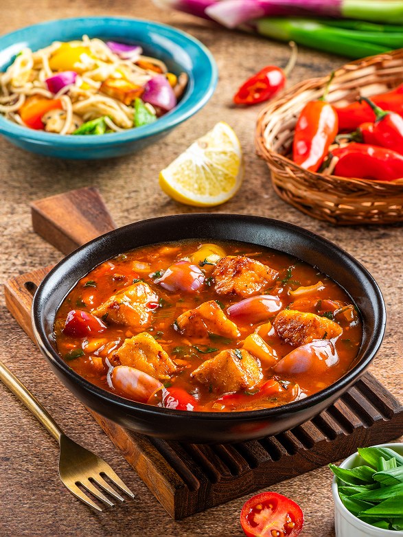 Cheese Chilly in a glossy red gravy with capsicum and onion