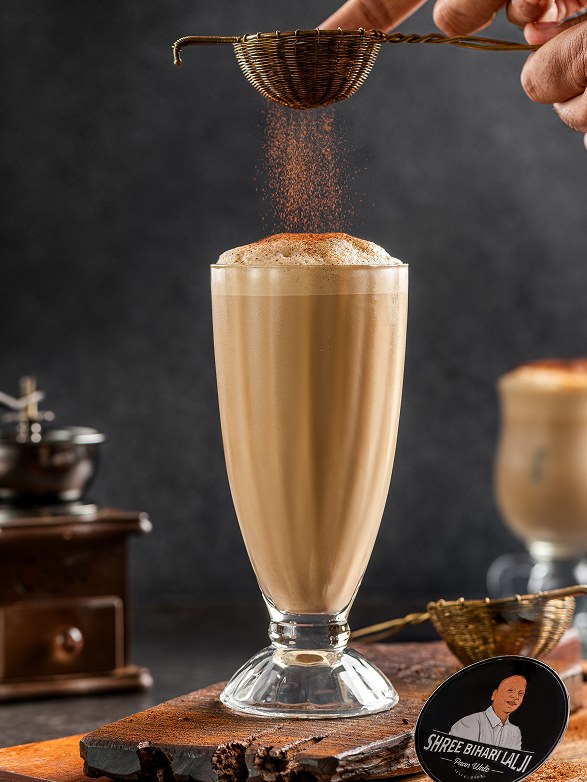 Classic Cold Coffee being dusted with cocoa